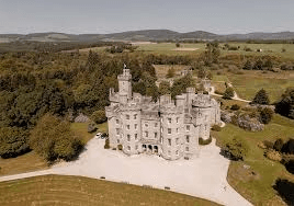 Aerial view of a historic Scottish castle venue with towers and surrounding woodland
