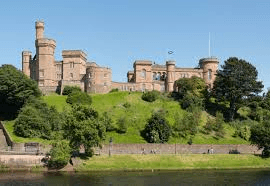 Inverness Castle on a wooded hill above the River Ness on a sunny day